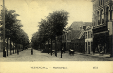 14675 Gezicht in de Hoofdstraat met bebouwing en rijen loofbomen te Veenendaal.